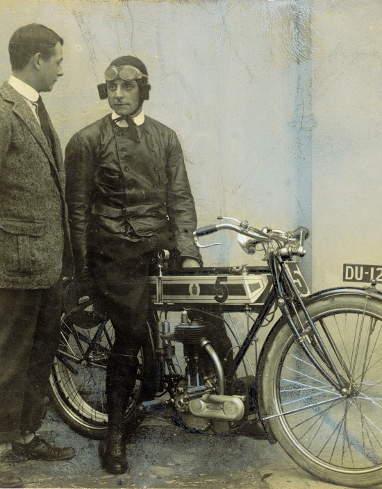 Jack Marshall, TT winner for Triumph in 1908, poses on his race mount. Gordon Gibson stands alongside.